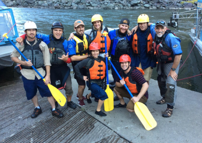 A group of eight whitewater rafting guide students posing for their guide school photo